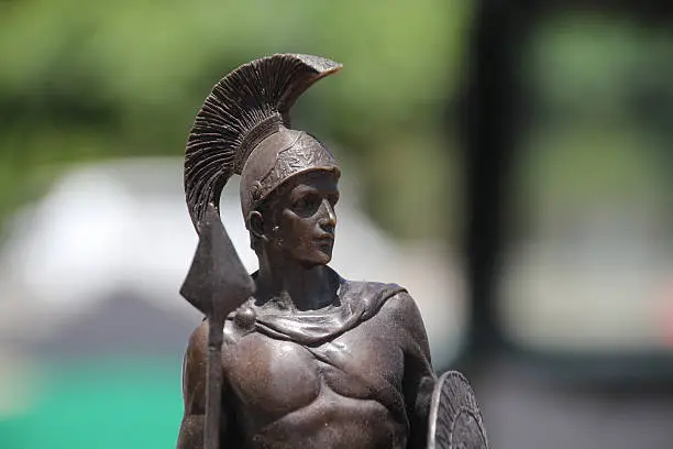a foreground statue of a Roman warrior