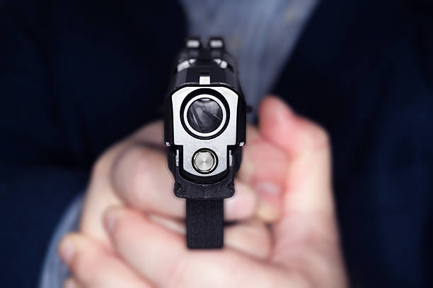 istock Hand holding a gun pointing straight at the camera 459463905