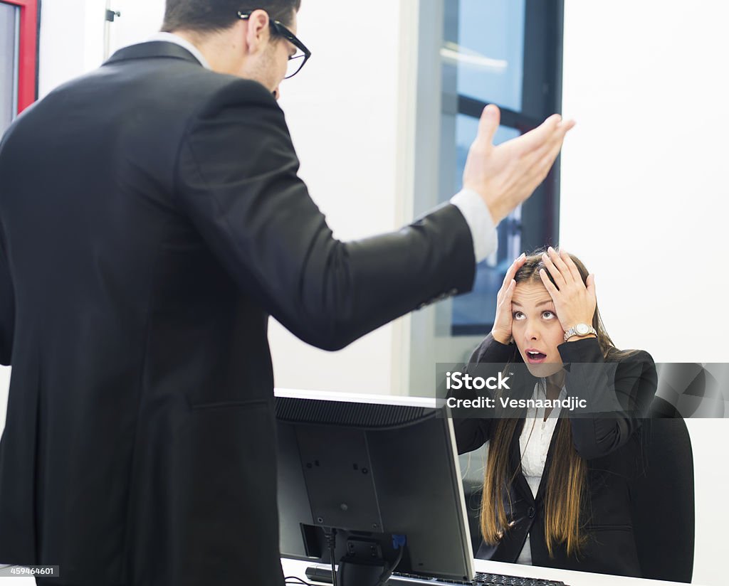 Business harassment Man screaming on woman at the office, woman holding for head 30-39 Years Stock Photo