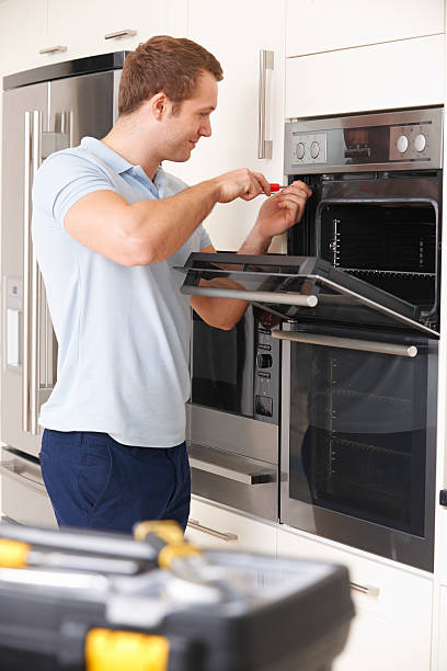 istock Man making repairs to an oven in a kitchen 459465389