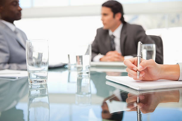 istock Businesswoman taking down notes as business men chats 459465571