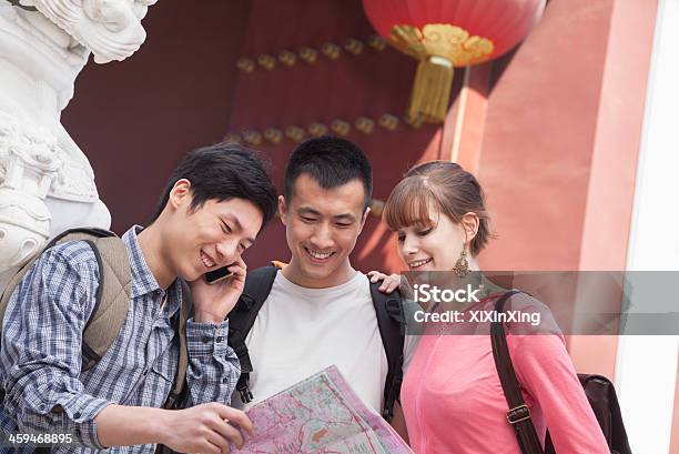 Three People Looking At Map Stock Photo - Download Image Now - China - East Asia, Map, 20-24 Years