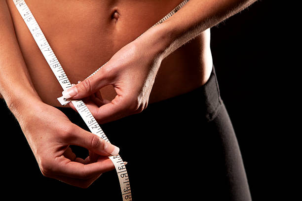 istock woman measuring her waist 459469997