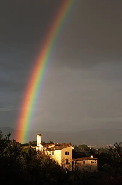 Rainbow over the hamlet of houses and the small bell. In the distance valleys of Tuscany and Florence with Brunelleschi's dome