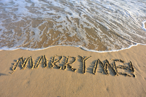 marry me word drawn on the beach