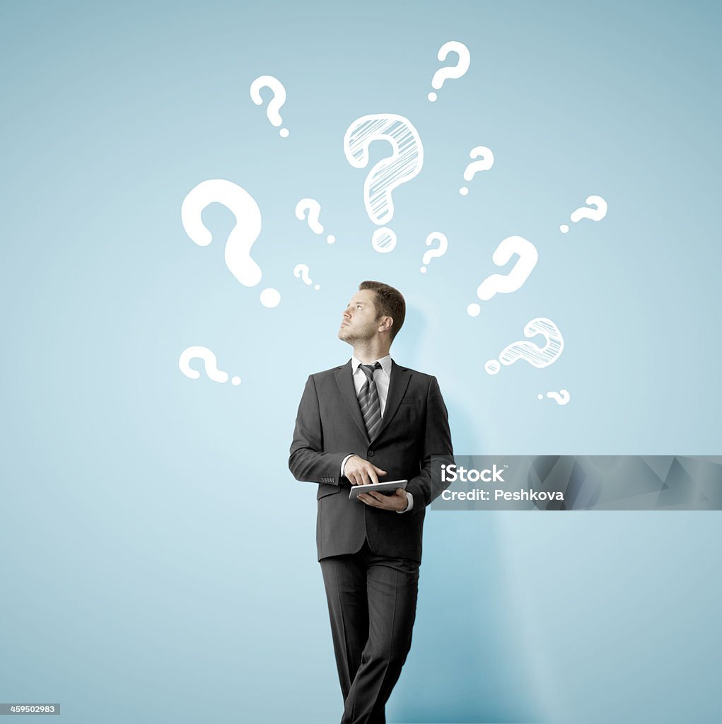 man with tablet businessman with tablet looking at wall with question mark Adult Stock Photo