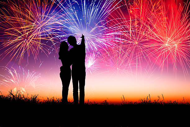 istock young couple standing on the hill and watching fireworks 459511987