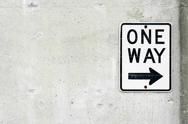 One way sign on concrete wall stock photo