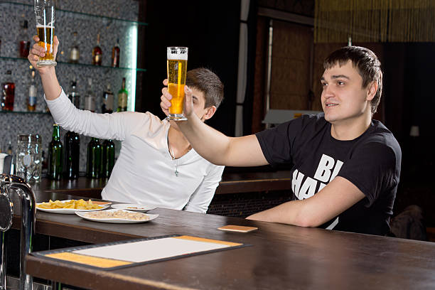 istock Two men raising their beer glasses in a toast 459519797