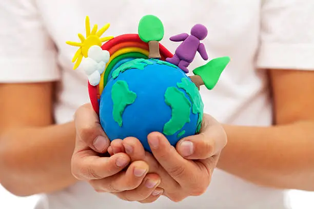 Life on earth - environment and ecology concept with clay earth globe in child hands