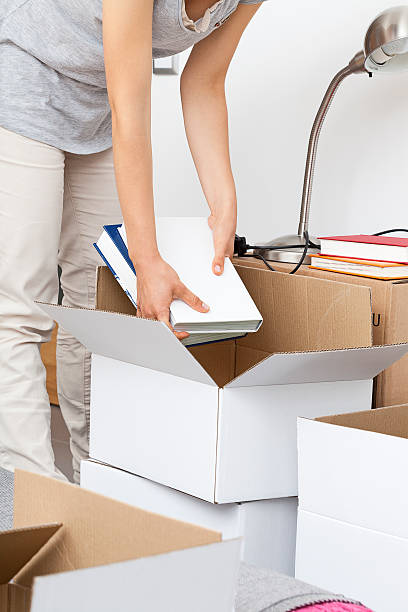istock Woman packing books 459520839