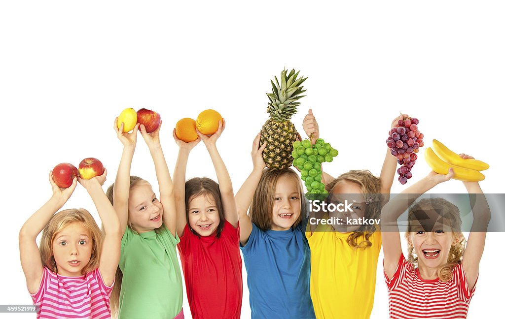 Group of smiling children holding fruits over their heads Group of happy children with fruits Child Stock Photo