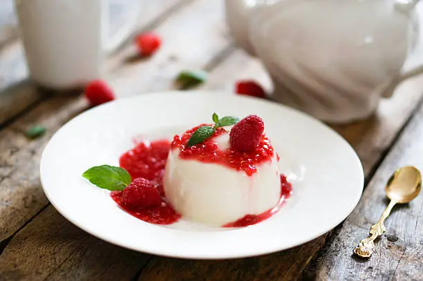 Photo of Delicious italian dessert panna cotta with raspberry sauce and mint