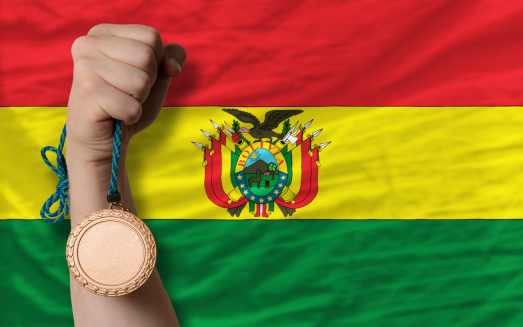 Holding bronze medal for sport and national flag of bolivia