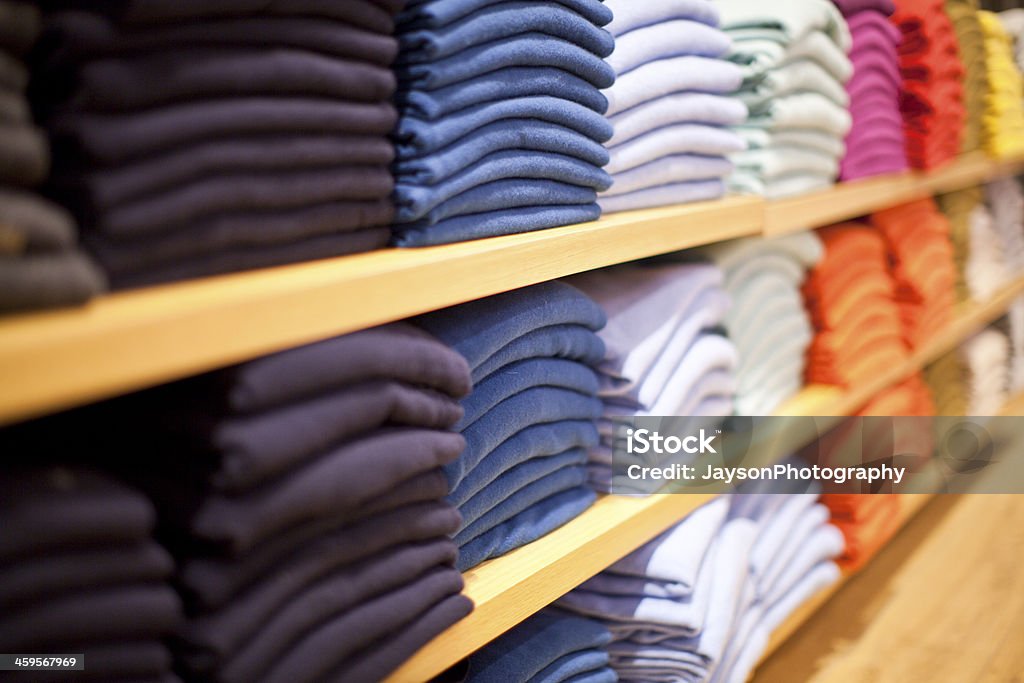 Stacks of different colored sweaters on store shelves Different color of Sweaters for sale Sweater Stock Photo