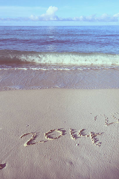 istock Year 2014 written in sand, on tropical beach 459568523