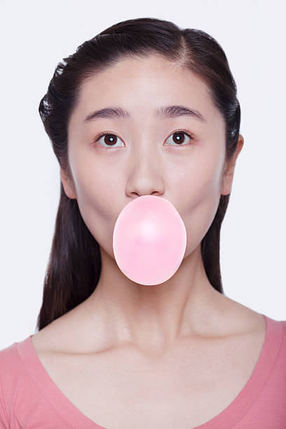 istock Young playful woman blowing a bubble 459589133