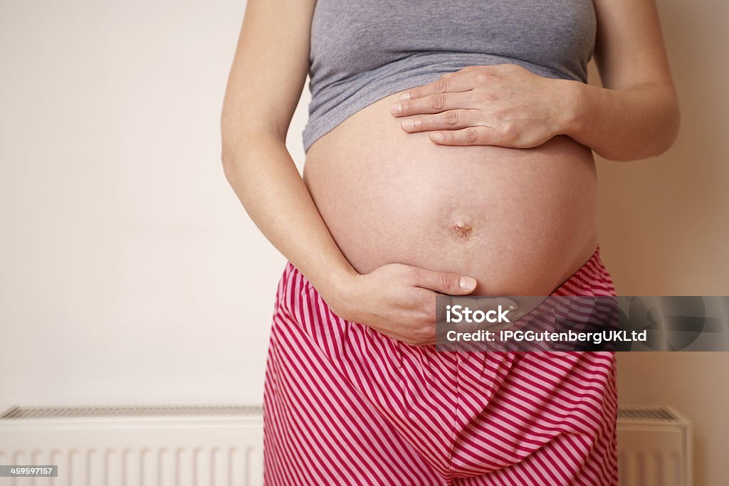 Sezione centrale di una paziente incinta toccare pancia - Foto stock royalty-free di Addome