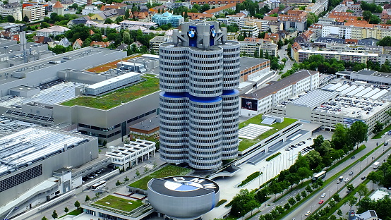 Munich, Germany - June 10, 2013: photo was taken from top of Olympic Park Tower, near BMW complex. Photo shows BMW adminstrative building,a modern building composed of four cylindrical towers, museum building with large BMW logo on top and part of BMW Munich factory.