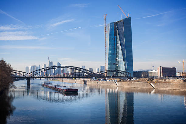Cargo ship on River Main. In the backgrounf ECB, European Central Bank Frankfurt - construction site and Deutschherrenbruecke (railway bridge), December 2013.