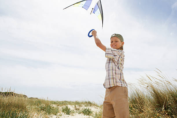 istock Portrait Of Boy Flying Kite On A Windy Beach 459615437
