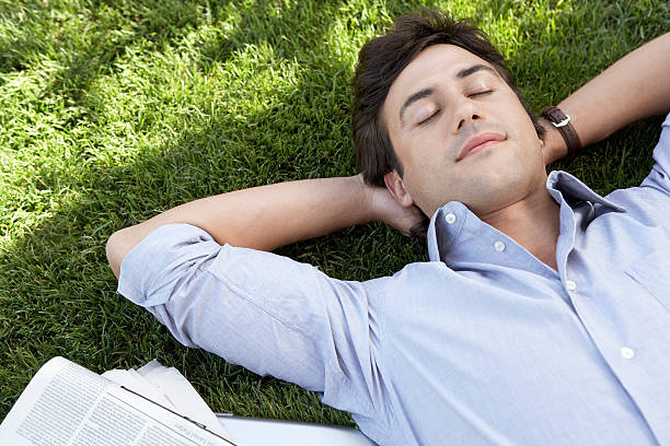 istock Relaxed Businessman Lying On Grass At Park 459642843
