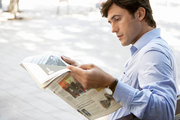 istock Businessman Reading Newspaper On Bench 459642871