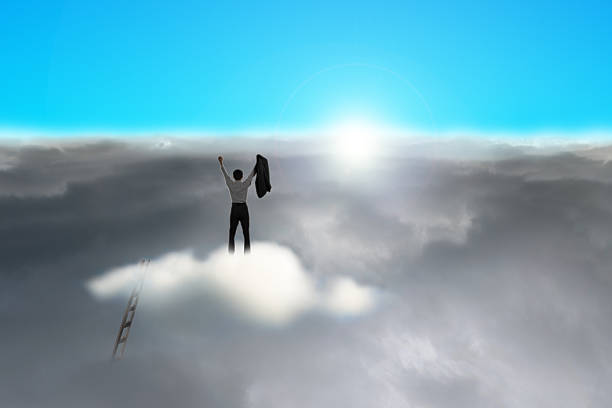istock Businessman standing on cloud against sun 459675523