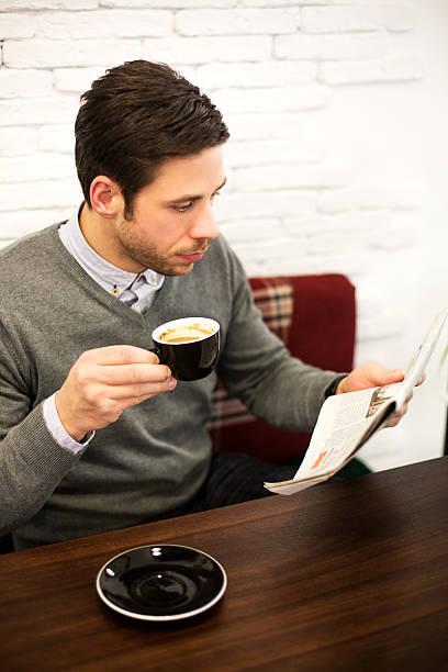 istock Male sitting in cafe and reading newspaper 459712601