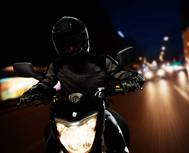 istock Young Man riding a motorcycle at night 459730571