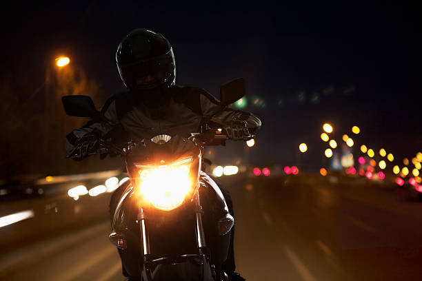junger mann reiten ein motorrad bei nacht - xing stock-fotos und bilder