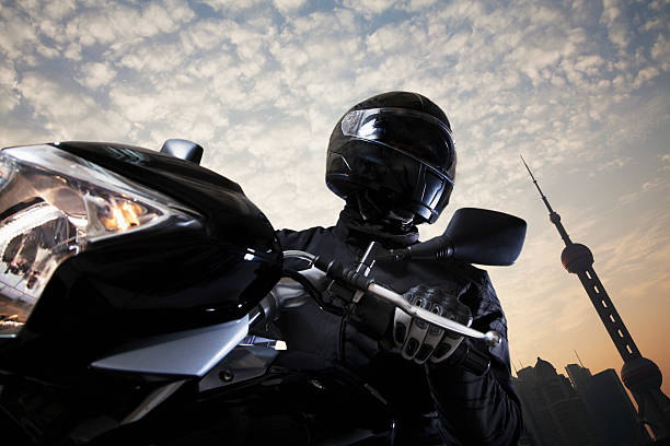 jovem dirigindo um motociclo durante o dia - motorcycle biker riding motorcycle racing imagens e fotografias de stock