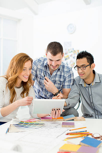istock Young Architects review blueprints at office. 459857649