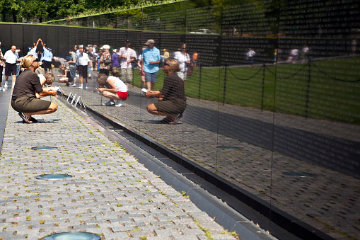 Washington, USA - July 15, 2010: people visit the Vietnam War Veterans Memorial in Washington DC, USA. Names in chronological order,from first casualty in 1959 to last in 1975.