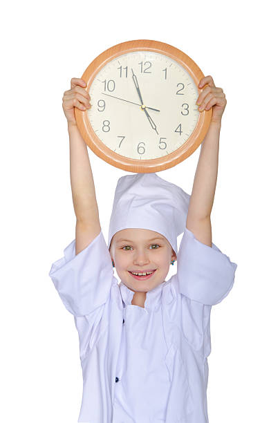 Young cook lifted up the clock Young cook lifted up the clock isolated on white ticker tape machine stock pictures, royalty-free photos & images