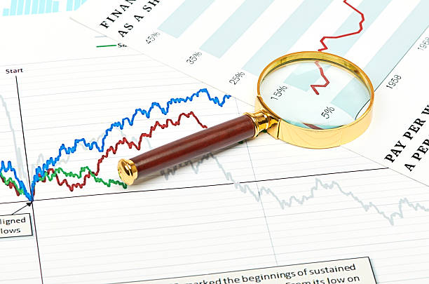 magnifier на графики. - interest rate stock exchange newspaper finance стоковые фото и изображения