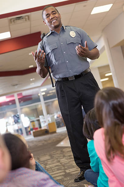 istock School security or police officer teaching safety procedures to students 459866299