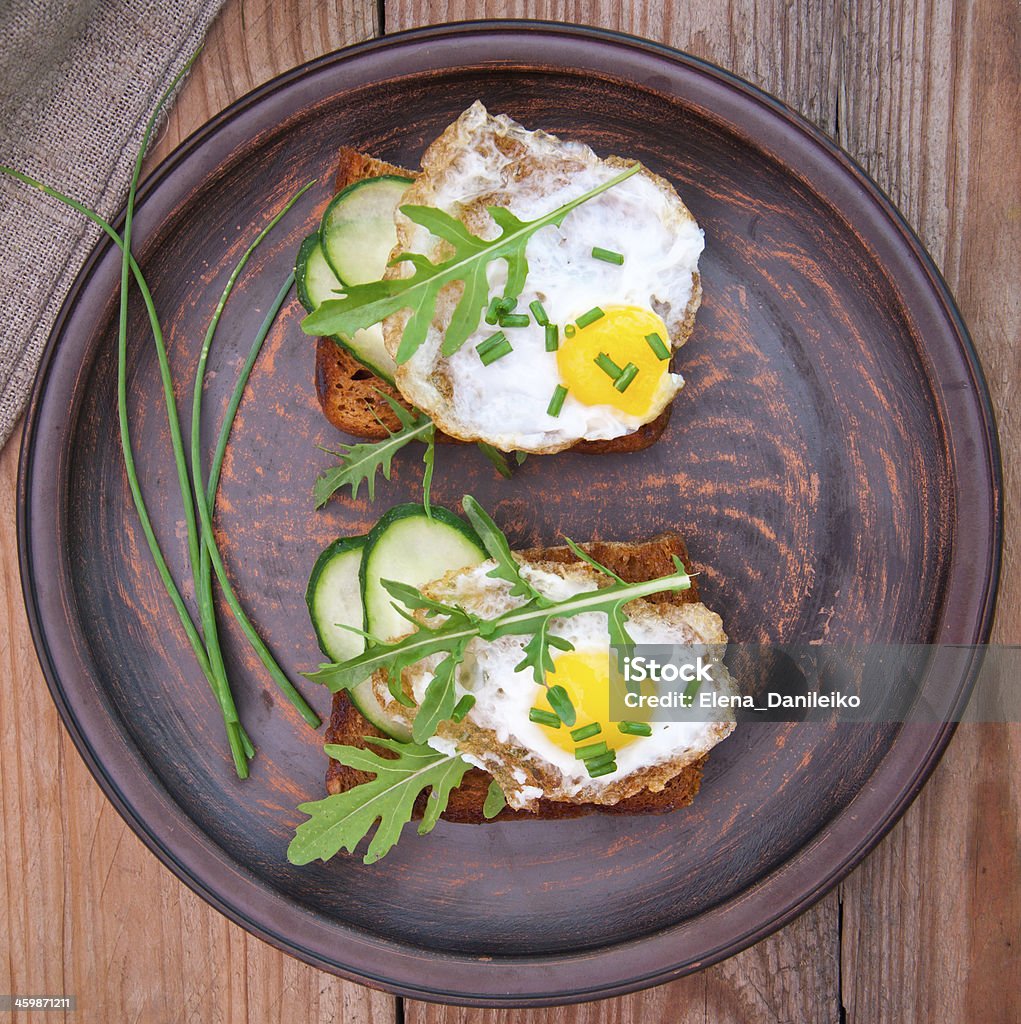 toast with fried egg, cucumber and arugula Appetizer Stock Photo