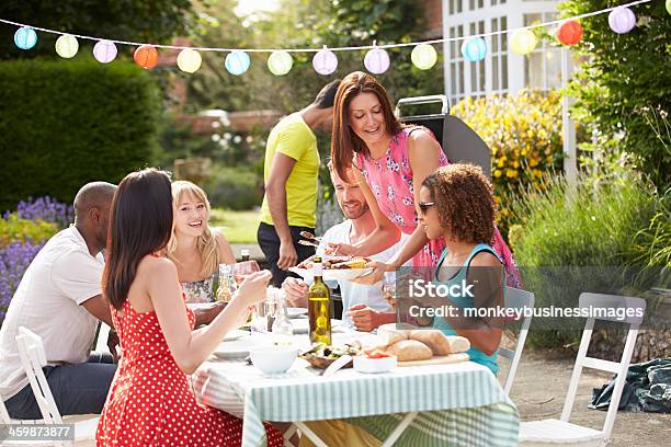 Gruppo Di Amici Avendo Barbecue Allaperto A Casa - Fotografie stock e altre immagini di Giardino domestico - Giardino domestico, Buffet, Amicizia