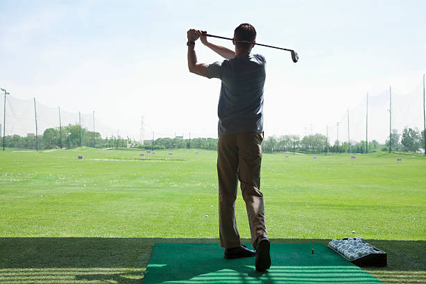 istock Man hitting golf balls on the course, arms raised 459873941
