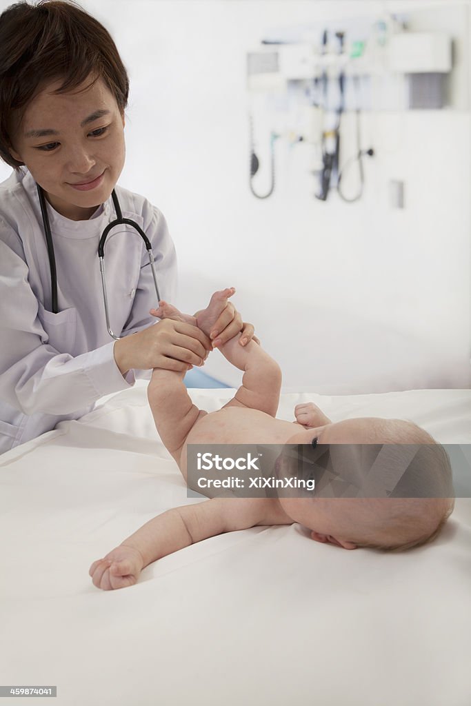 Smiling doctor examining a baby in the doctors office 2-5 Months Stock Photo