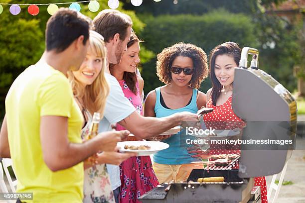 Group Of Friends Having Outdoor Barbeque At Home Stock Photo - Download Image Now - Grilled, Friendship, Summer