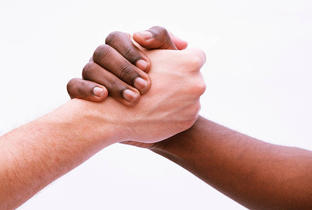 istock Two young men shaking hands, close-up, studio shot 459874551