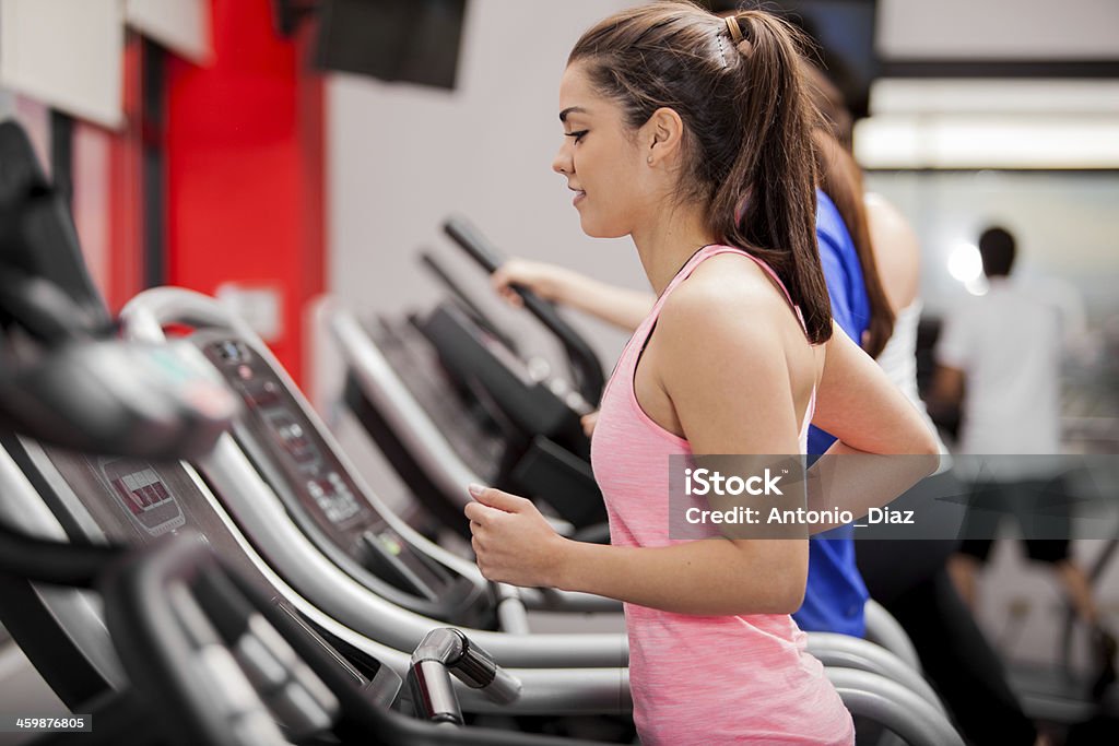 Beautiful brunette on a treadmill Cute young Latin woman exercising on a treadmill at a gym 20-29 Years Stock Photo