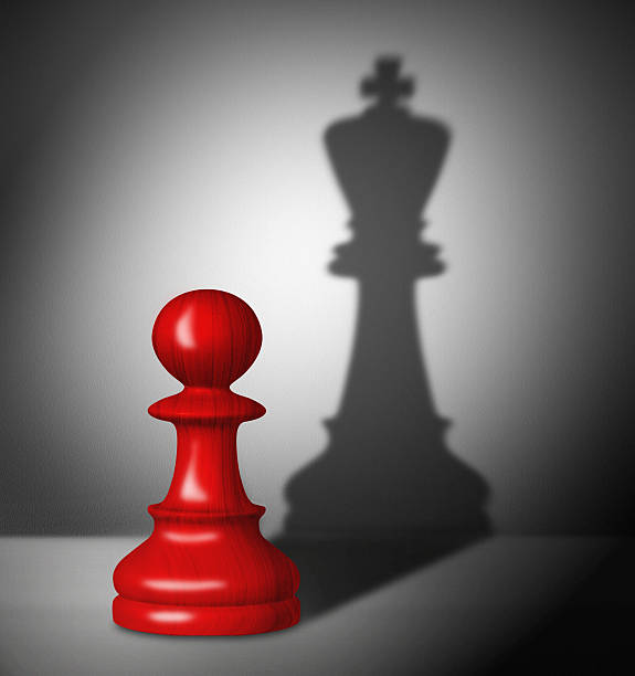 Chess pawn with the shadow of a king. chess pawn with the shadow of a king. pawn chess piece photos stock pictures, royalty-free photos & images