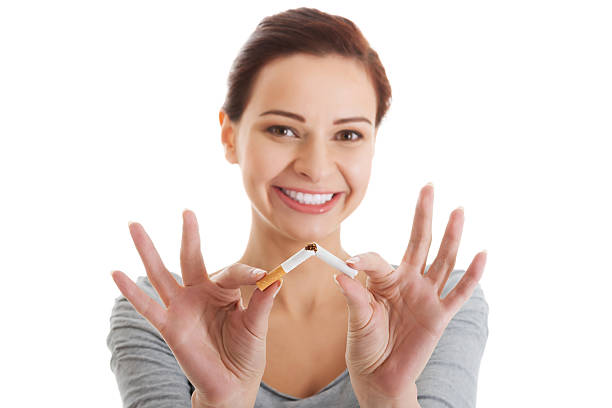 Young beautiful woman holding broken cigarette. stock photo