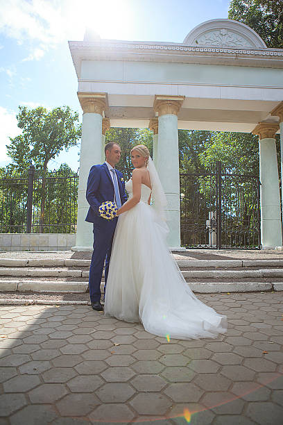 istock Newlyweds standing near arches with columns 459877921