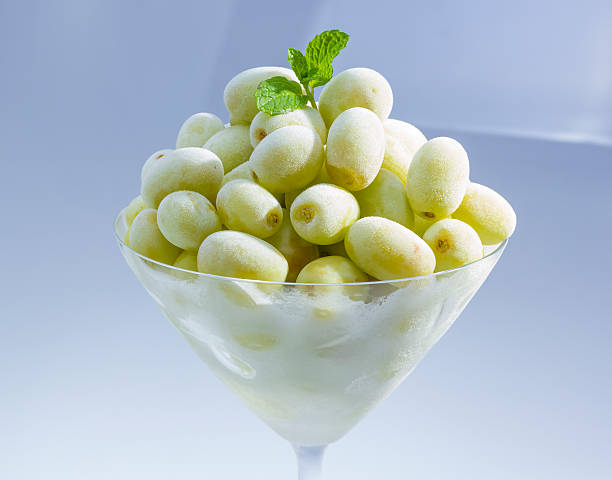 Frozen grape in martini glass. Frozen green grape in martini glass with peppermint . frozen grapes stock pictures, royalty-free photos & images