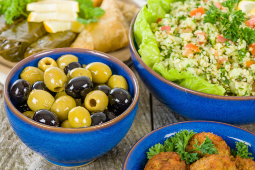 Selection of Middle Eastern dishes. Tabbouleh, falafel, olives, sarma, spinach borek, fatayer, hummus and pita bread.