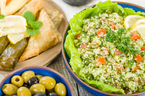 Selection of Middle Eastern dishes. Tabbouleh, falafel, olives, sarma, spinach borek, fatayer, hummus and pita bread.